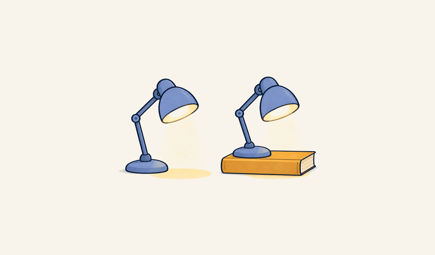 Two blue desk lamps cast light, with one resting on a mustard-colored instruction book.